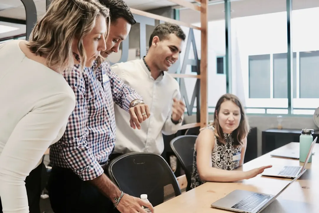 A developer and product manager reviewing an HR platform integration diagram showing automated milestone gifting triggered by employee lifecycle events