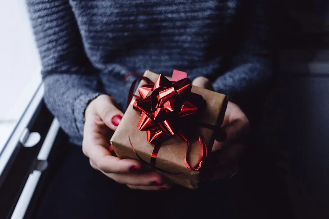 Wrapped gift box with ribbon on a warm background, representing a real physical gift sent between users on a digital platform